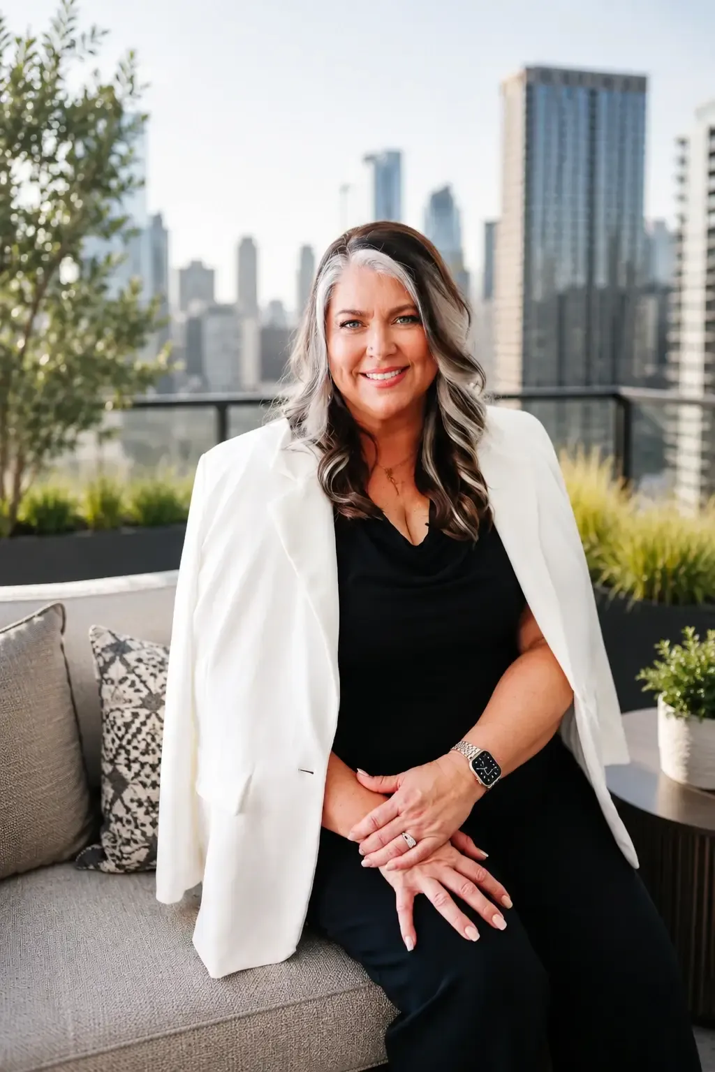 Teresa Lodato seated on a rooftop terrace with the city skyline behind her