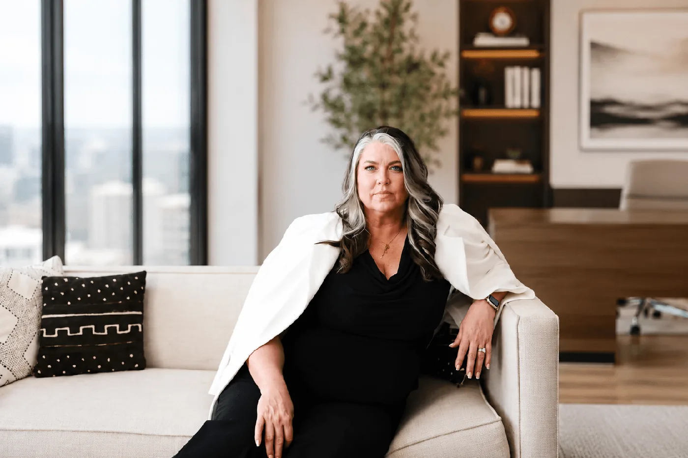 Teresa Lodato seated on an office sofa by the window